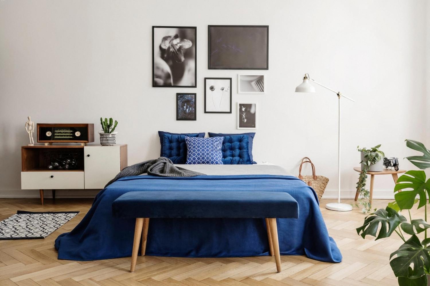 Blue upholstered bench and bed in a bright bedroom, showing fabric surfaces that collect dust